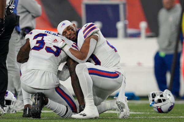 Buffalo Bills’ Siran Neal (33) and Nyheim Hines react after teammate Damar Hamlin was injured Monday.
