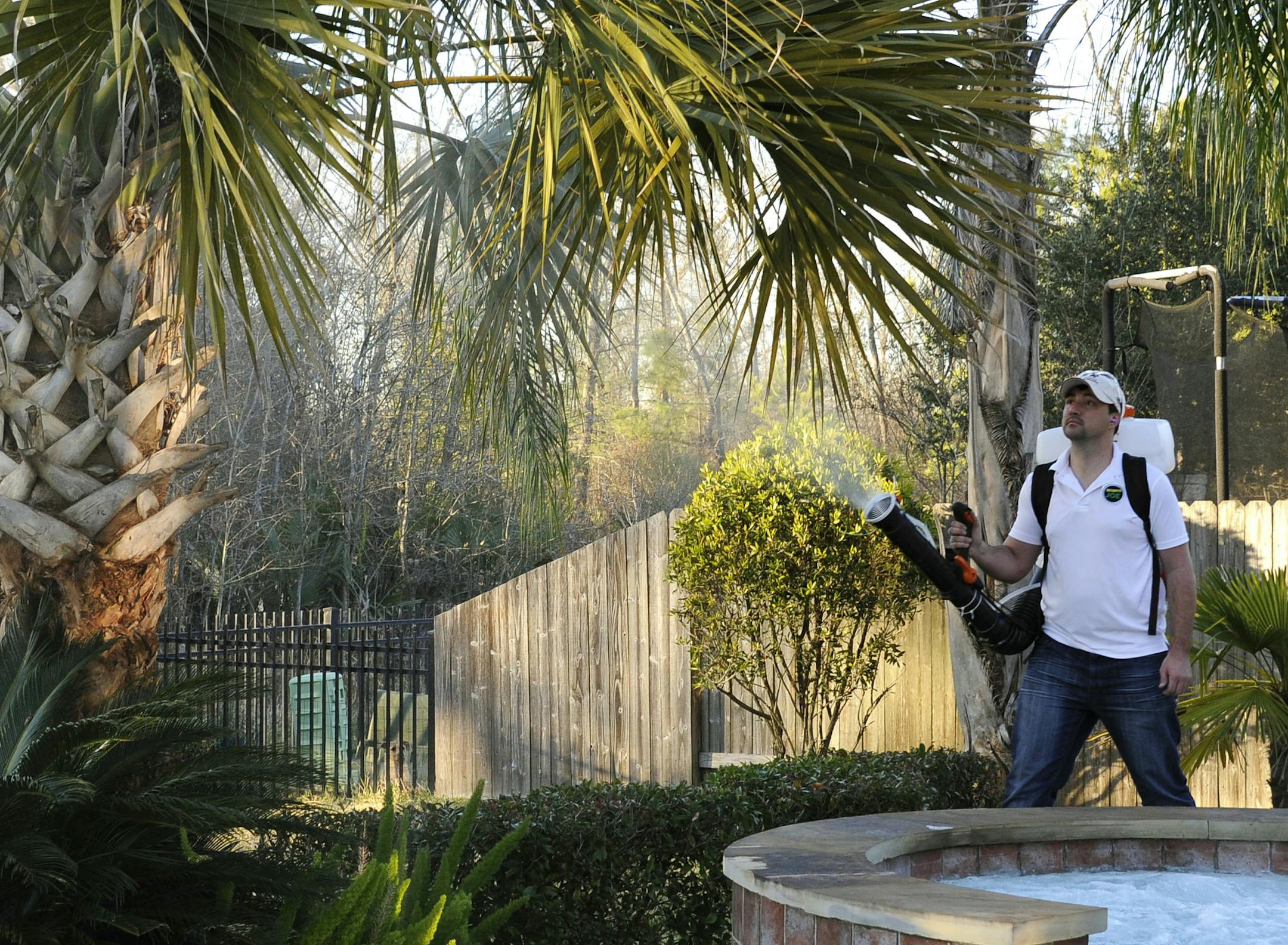In this Wednesday, Feb. 10, 2016 photo, Darryl Nevins, owner of a Mosquito Joe franchise, sprays a backyard to control mosquitoes, in Houston. Pest control companies in Texas are getting an early surge in business because of concerns that mosquitoes bearing the Zika virus will arrive from neighboring Mexico. (AP Photo/Pat Sullivan) ORG XMIT: TXPS103