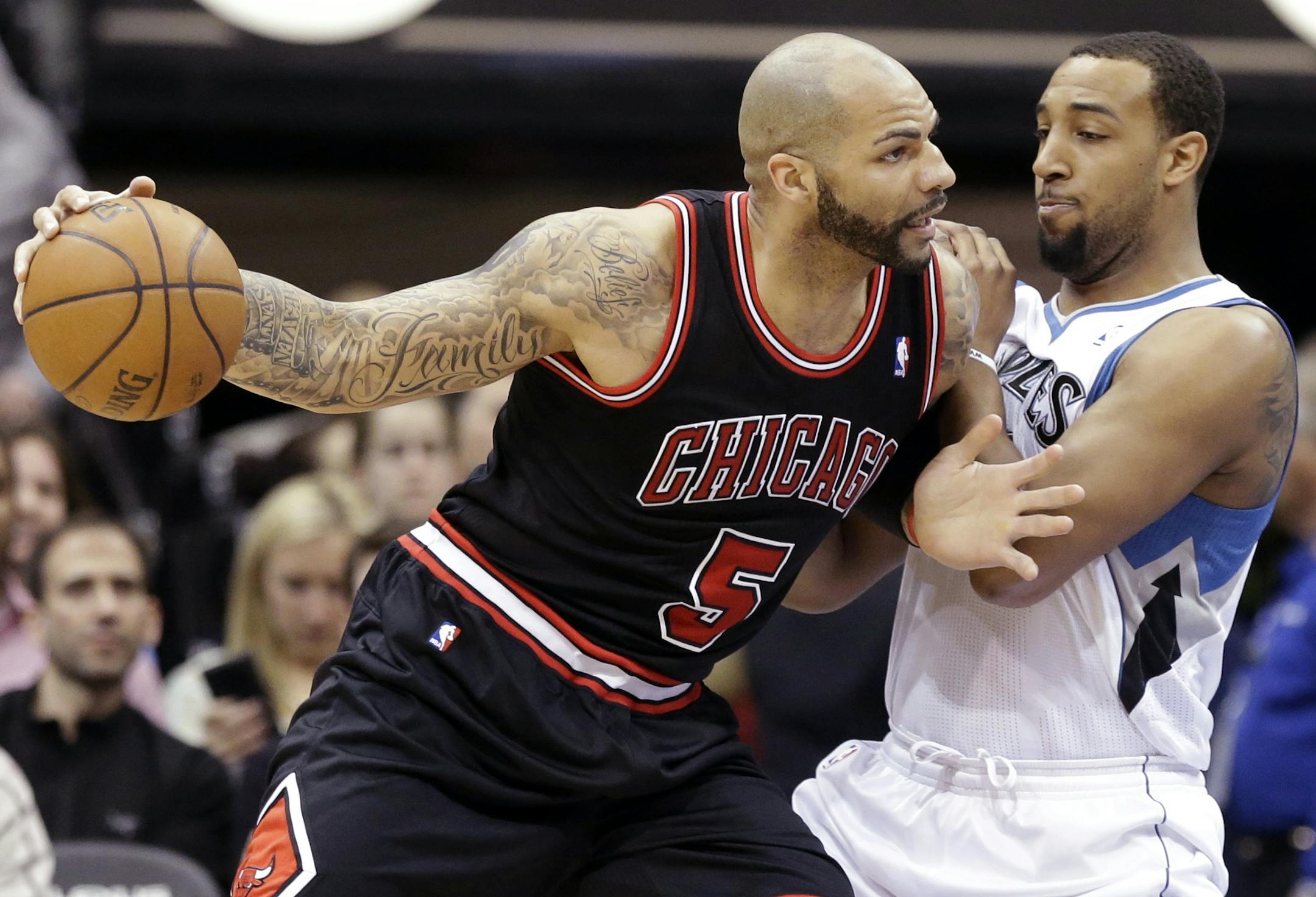 Chicago Bulls' Carlos Boozer, left, drivves around Minnesota Timberwolves' Derrick Williams in the first quarter of an NBA basketball game Sunday, March 24, 2013, in Minneapolis. (AP Photo/Jim Mone)