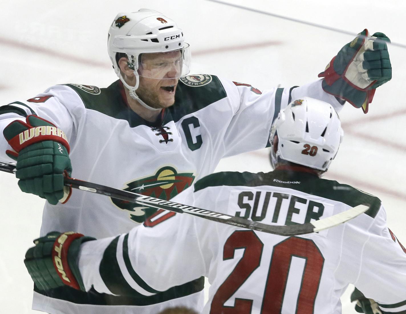 Minnesota Wild center Mikko Koivu (9) celebrates his goal with defenseman Ryan Suter (20) during overtime in Game 5 in the first round of the NHL Stanley Cup playoffs against the Dallas Stars on Friday, April 22, 2016, in Dallas. The Wild won 5-4. (AP Photo/LM Otero)