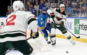 Minnesota Wild center Joel Eriksson Ek (14) passes the puck against the St. Louis Blues during the first period of an NHL hockey game on Saturday, Mar