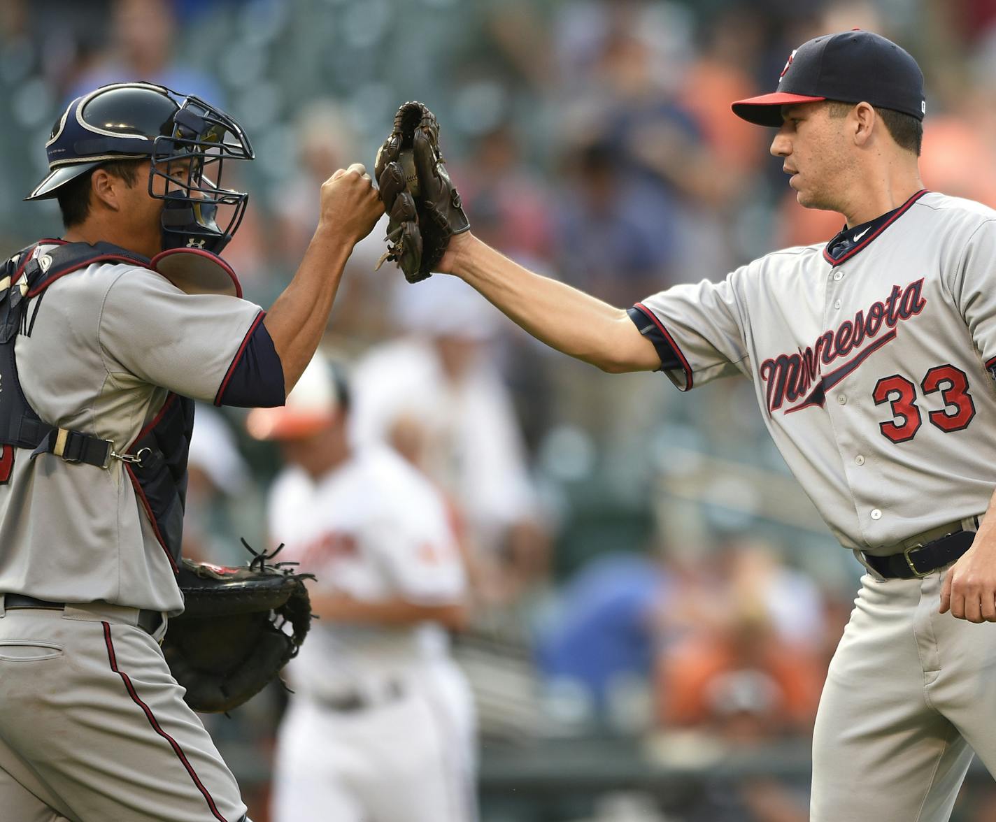 Minnesota Twins relief pitcher Tommy Milone (33) celebrates 4-3 win in 12 innings over the Baltimore Orioles with catcher Kurt Suzuki, left, after a baseball game, Sunday, Aug. 23, 2015, in Baltimore. (AP Photo/Nick Wass)