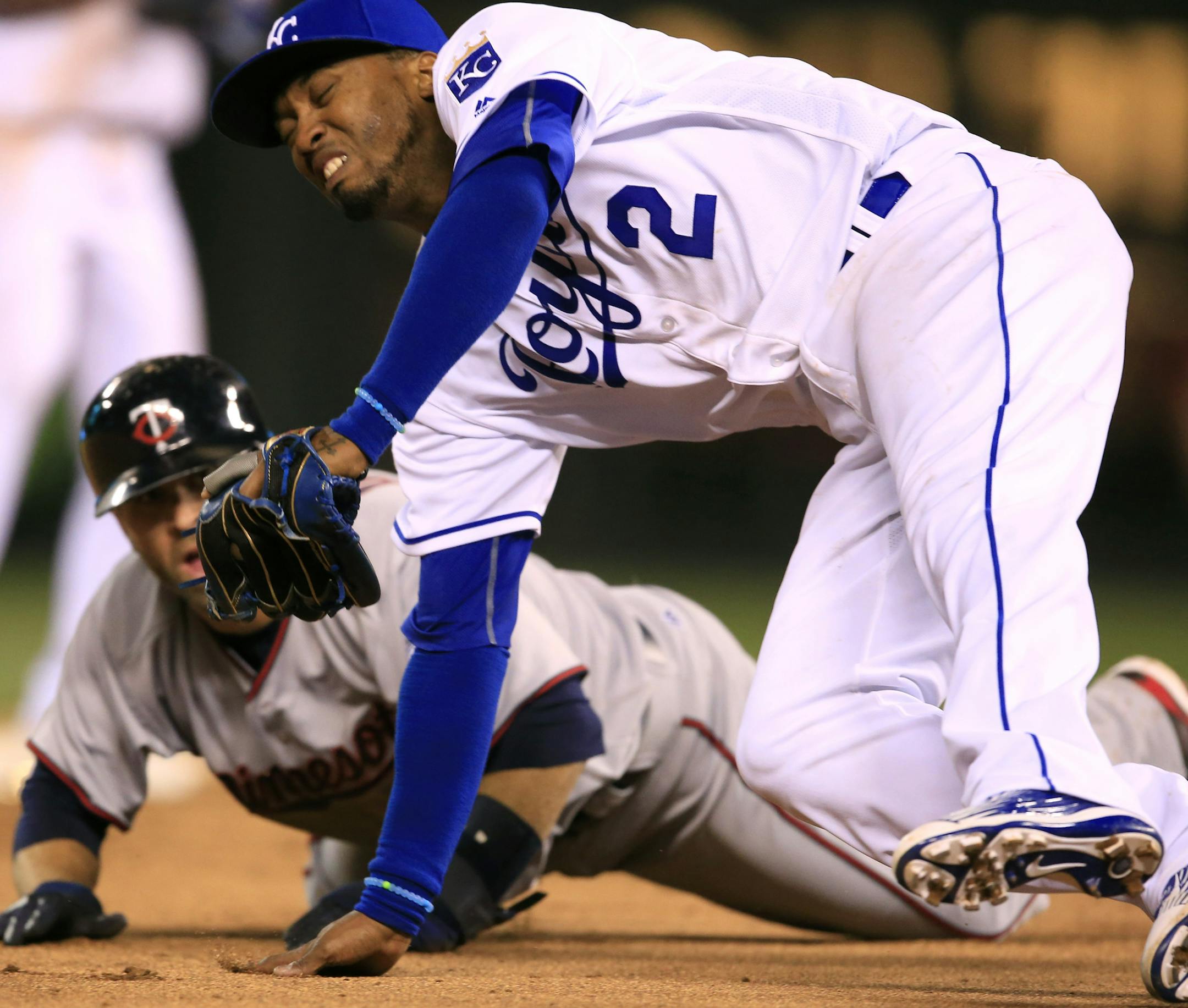 Kansas City Royals shortstop Alcides Escobar (2) falls over Minnesota Twins' Brian Dozier during a rundown between second and third bases in the ninth inning of a baseball game at Kauffman Stadium in Kansas City, Mo., Friday, April 8, 2016. Dozier was out on the play. The Royals defeated the Twins 4-3. (AP Photo/Orlin Wagner)