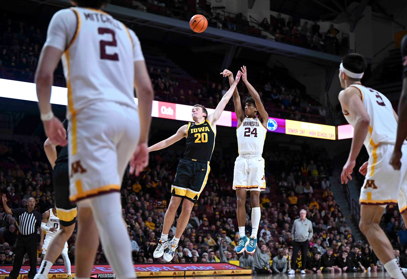 Minnesota Gophers guard Cam Christie (24) hits a 3-pointer under pressure by Iowa Hawkeyes forward Payton Sandfort (20) in the second half Monday, Jan. 15, 2024 at Williams Arena in Minneapolis, Minn..