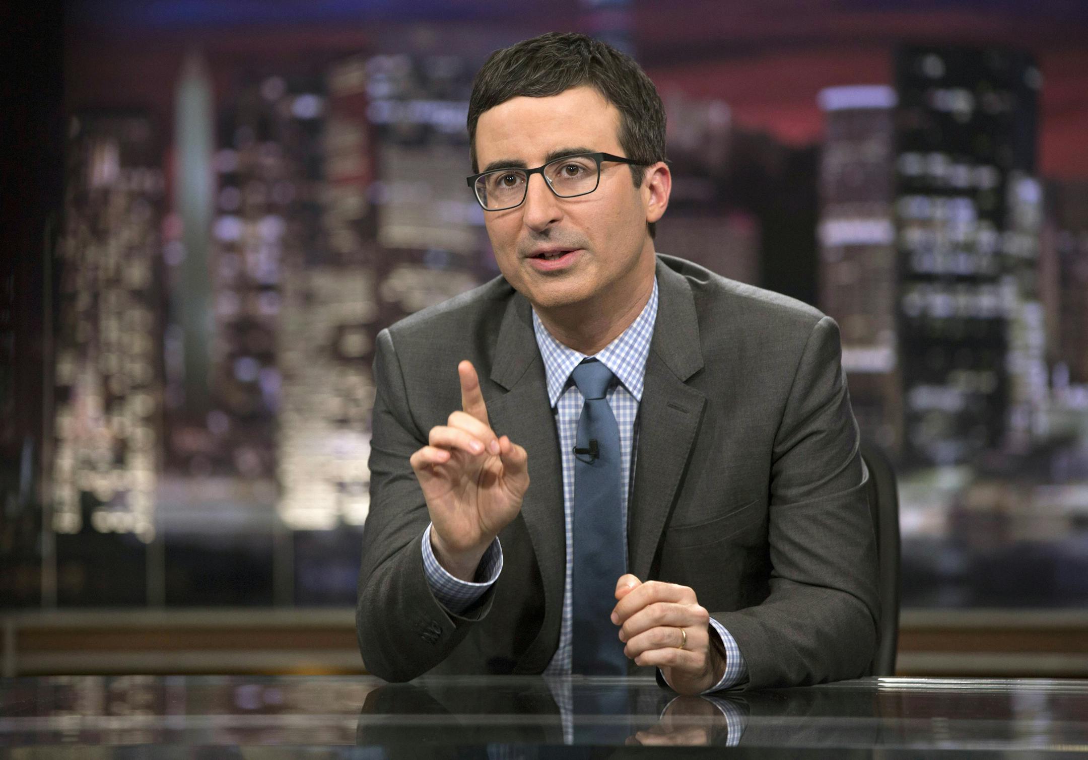 In this April 2014 image released by HBO, host John Oliver speaks during "Last Week Tonight with John Oliver," in New York. Oliver, who subbed for Jon Stewart as host of "The Daily Show" last summer and began his own HBO weekly show in April, often devotes about half of his 30 minutes to a single topic below the headlines. His subsequent report questioning the pageant's scholarship program was the latest example of how Oliver has quickly moved beyond his roots at "The Daily Show" to produce some