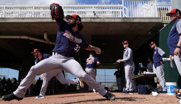 Minnesota Twins pitcher Tim Collins (37) delivered a pitch under the watchful eye of pitching coach Wes Johnson, right, in the bullpen Sunday. ] ANTHO