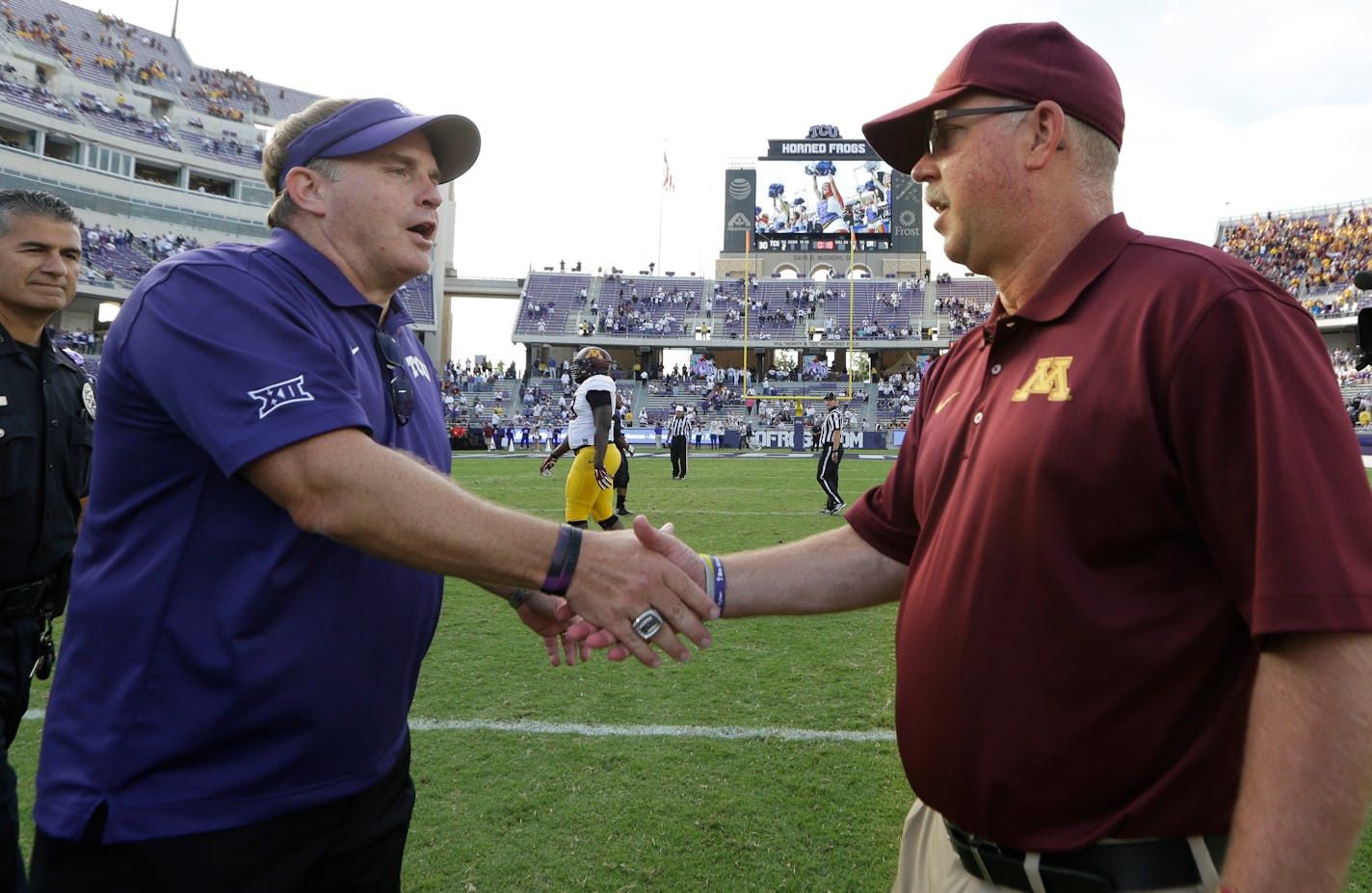 TCU head coach Gary Patterson, left, shakes hands with Minnesota head coach Jerry Kill after an NCAA college football game, Saturday, Sept. 13, 2014, in Fort Worth, Texas. TCU won 30-7. The two teams open the season Thursday in Minneapolis.