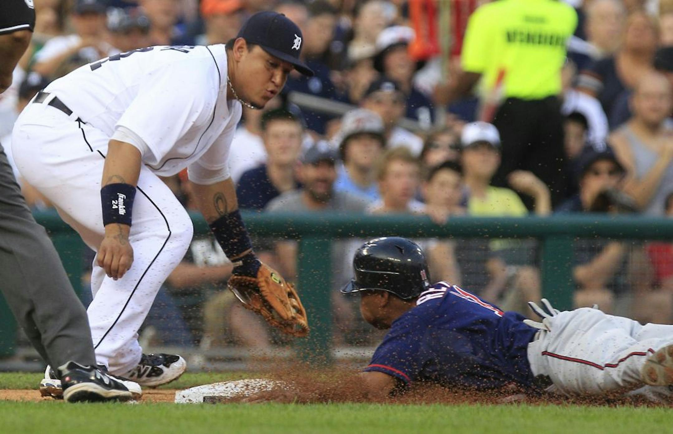 Minnesota Twins' Ben Revere safely slides under the tag of Detroit Tigers third baseman Miguel Cabrera during the fifth inning of a baseball game in Detroit, Monday, July 2, 2012.