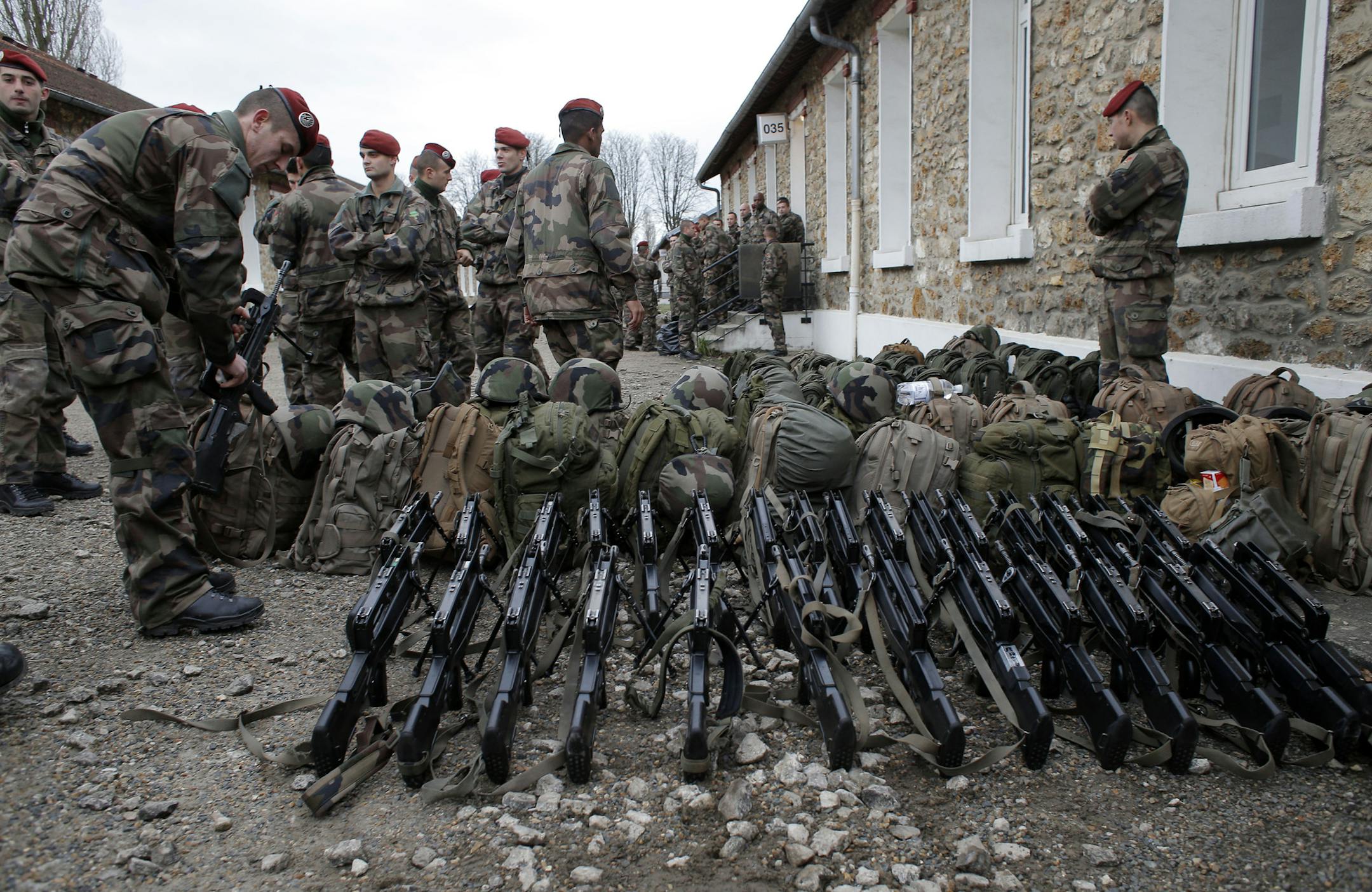 French soldiers prepare before patrolling, at the Satory military camp in Versailles, west of Paris, France, Tuesday, Jan. 13, 2015. France on Monday ordered 10,000 troops into the streets to protect sensitive sites after three days of bloodshed and terror, amid the hunt for accomplices to the attacks that left 17 people and the three gunmen dead. (AP Photo/Christophe Ena)