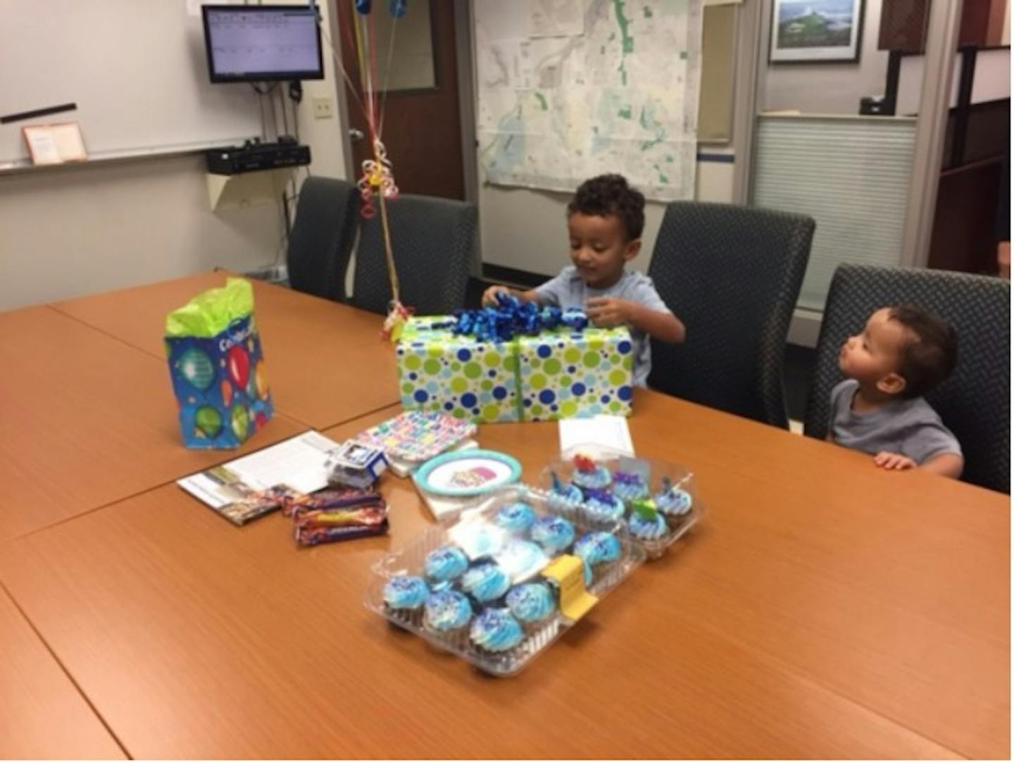 Gabriel Abdirahman opens a birthday present at a surprise party thrown for him by the Mendota Heights police department.