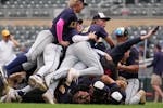 Totino-Grace’s Tommy Heifort (20) is mobbed by his teammates after getting the final out in the seventh inning of the 3A baseball championship game 
