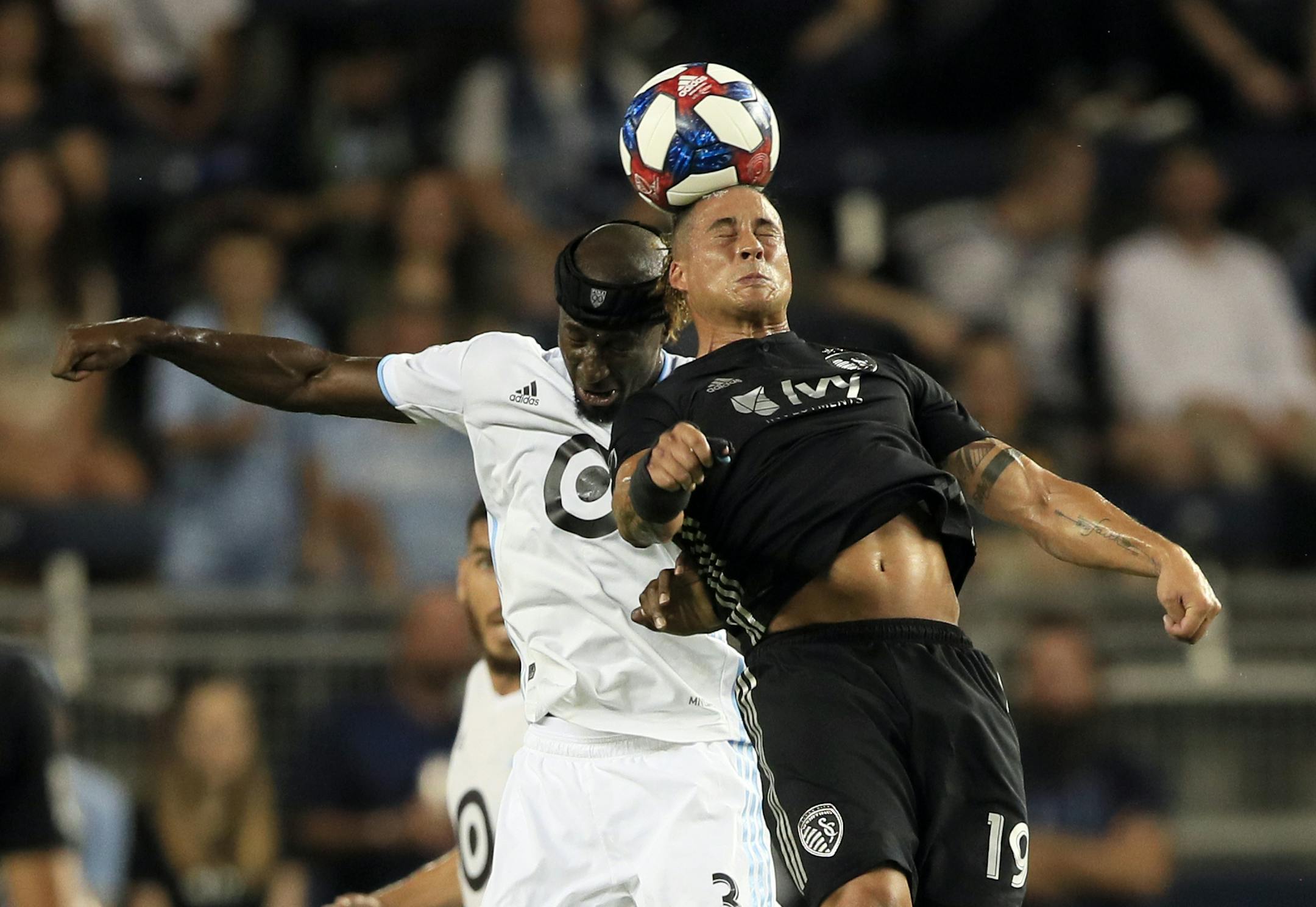 Minnesota United defender Ike Opara (3) and Sporting Kansas City forward Erik Hurtado (19) head the ball during the first half of an MLS soccer match in Kansas City, Kan., Thursday, Aug. 22, 2019. (AP Photo/Orlin Wagner)