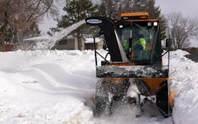 A Bloomington city worker clears a sidewalk. The city is considering a proposal to reduce the miles of sidewalks it plows, turning the job over to hom