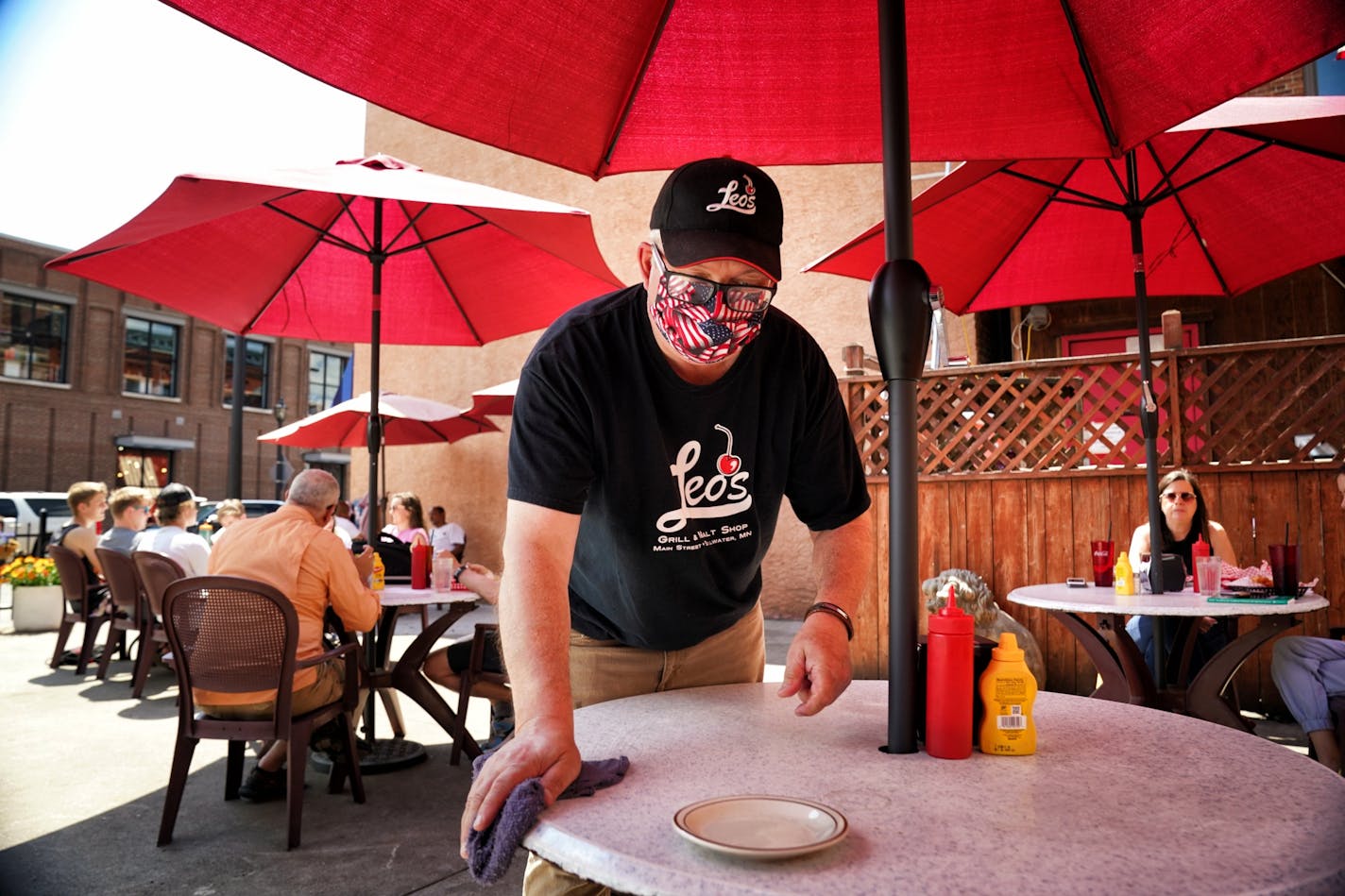 Howard Dale, host at Leo's Grill & Malt Shop in Stillwater sanaitized a table between customers. Monday was the first day Minnesota restaurants were allowed to serve customers outdoors.