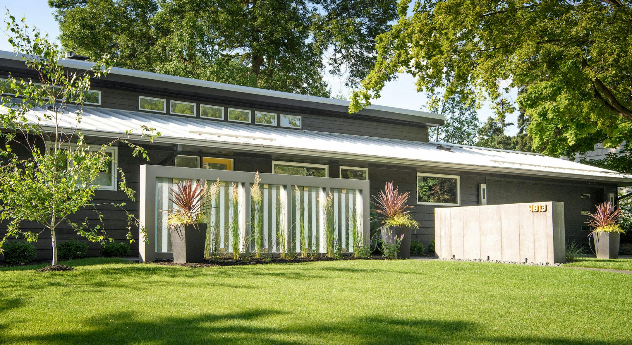 Concrete, glass and steel sculptural walls create an air of mystery around the front entry of the metal-roofed rambler, built in 1949 in Edina.