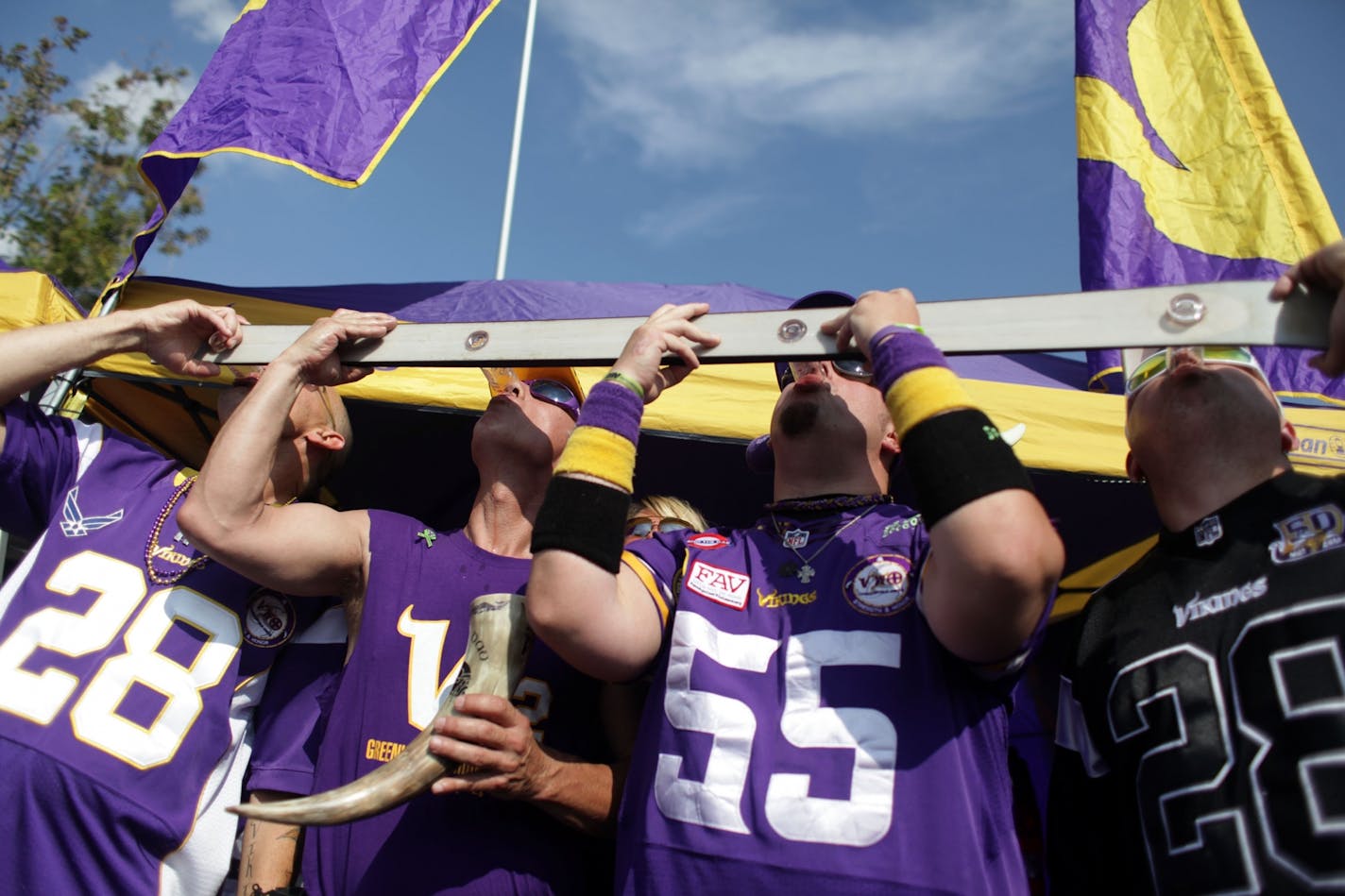 Grant Sparks, David Gunderson, Dan Rose, and Jamie Peterson take shots from a "shot ski" while tailgating outside of TCF Bank Stadium on Friday afternoon before the first pre-season home game.