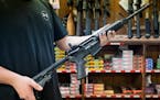An employee holds an AR-15 style rifle inside Clark Brothers Gun Shop in Warrenton, Va., Feb. 25, 2018. 