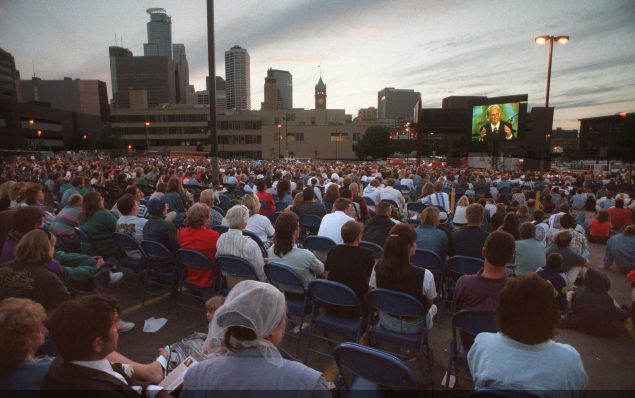Billy Graham preaching to an overflow crowd at the Metrodome -- Billy Graham appears on a Jumbotron set up before an overflow crowd at the metrodome.