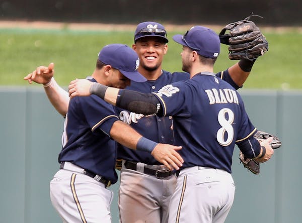 Carlos Gomez #27 of the Milwaukee Brewers, middle celebrated with teammates Ryan Braun #8 of the Milwaukee Brewers, right and Gerardo Parra #28 of the