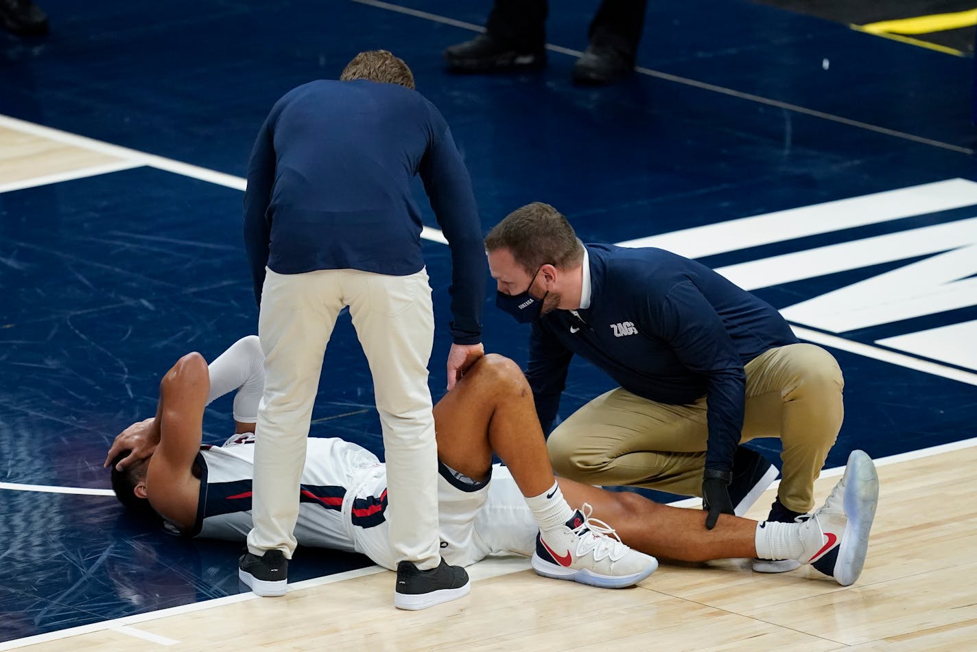 Gonzaga coach Mark Few stands over Jalen Suggs (1) as he is examined during the first half of the team's NCAA college basketball game against West Virginia, Wednesday, Dec. 2, 2020, in Indianapolis. (AP Photo/Darron Cummings)