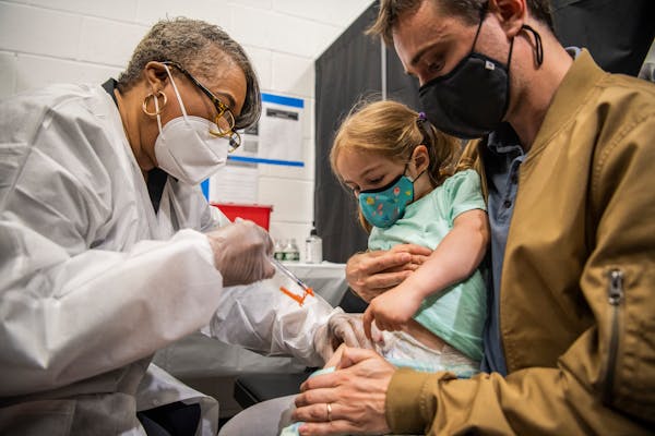 Cara Bookman, 2, got a shot of the Moderna coronavirus vaccine on her leg as her father, Max Bookman, held her at a vaccine site for children in Times