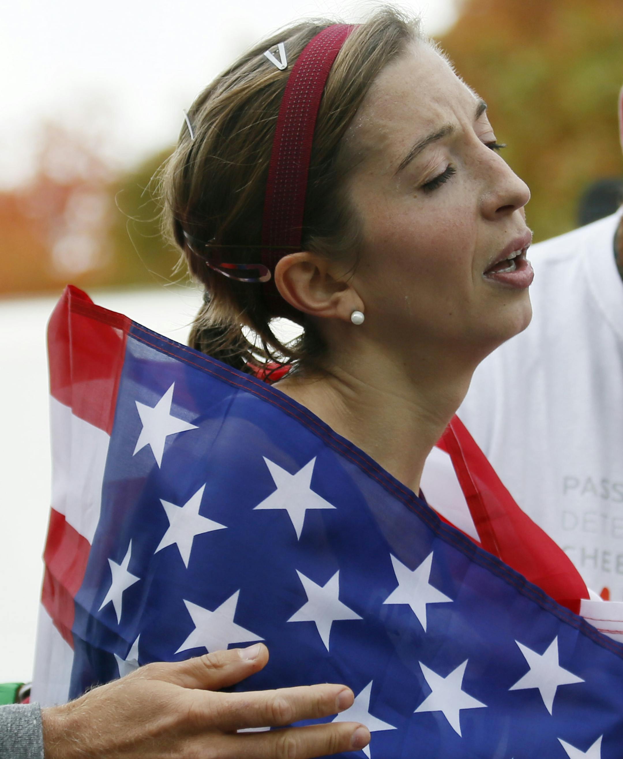 Annie Bersagel of Victoria, Minn., won the women‚Äôs race and the U.S. women‚Äôs marathon championship in an unofficial time of 2:31:11. Here Bersagel is draped in an american flag after crossing the finnish line. ] BRIAN PETERSON ‚Ä¢ brianp@startribune.com St. Paul, MN - 10/06//2013