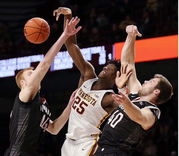 Minnesota's Daniel Oturu rebounds against Omaha's Mitchell Hahn (44) and Matt Pile (40) during Tuesday's action at Williams Arena.