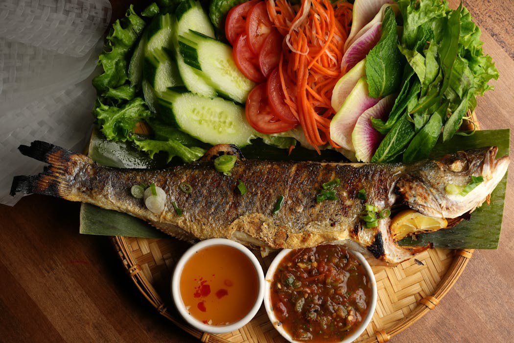 The branzino at Chelas, served with sides and sauces, makes a statement — and is a steal.