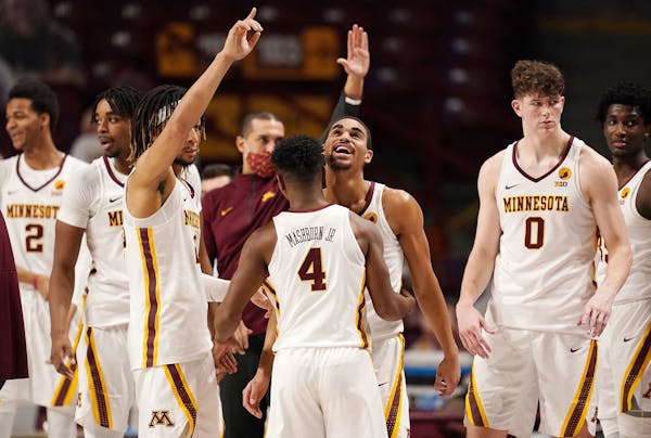 Minnesota guard Tre' Williams (1) and Minnesota guard Jamal Mashburn Jr. (4) celebrated after beating the Michigan Wolverines at the end of the second