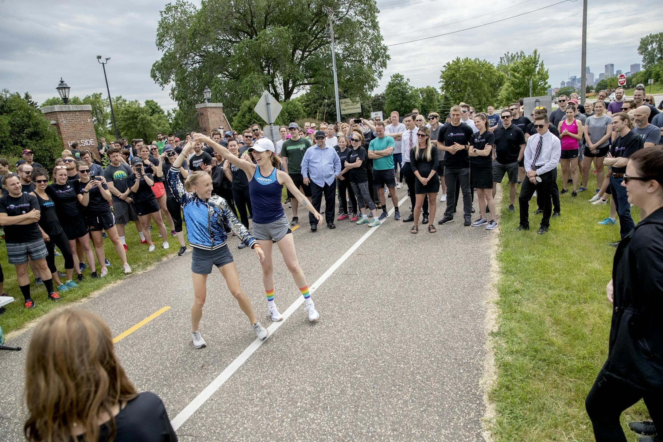 Gabriele Grunewald's running teammate Ladia Albertsonb-Junkans, left, and sister Abigail Anderson danced before family, friends, and supporters ran in honor of Grunewald.