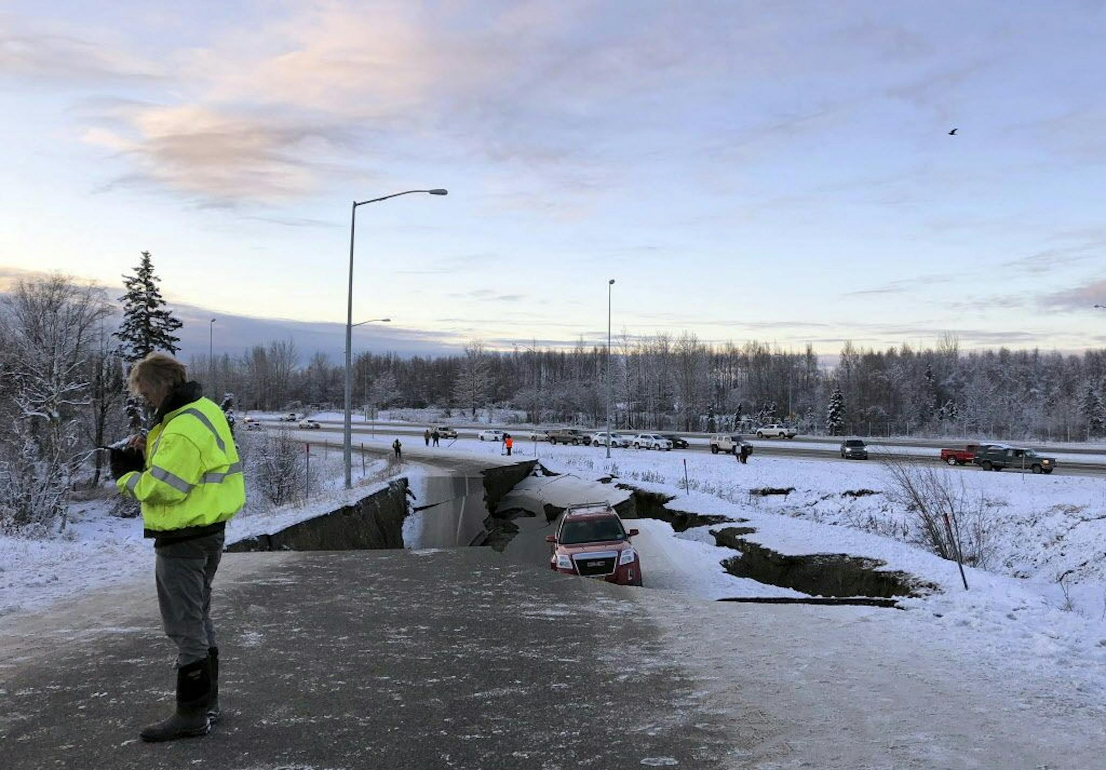 A car is trapped on a collapsed section of the offramp of Minnesota Drive in Anchorage, Friday, Nov. 30, 2018. Back-to-back earthquakes measuring 7.0 and 5.8 rocked buildings and buckled roads Friday morning in Anchorage, prompting people to run from their offices or seek shelter under office desks, while a tsunami warning had some seeking higher ground.