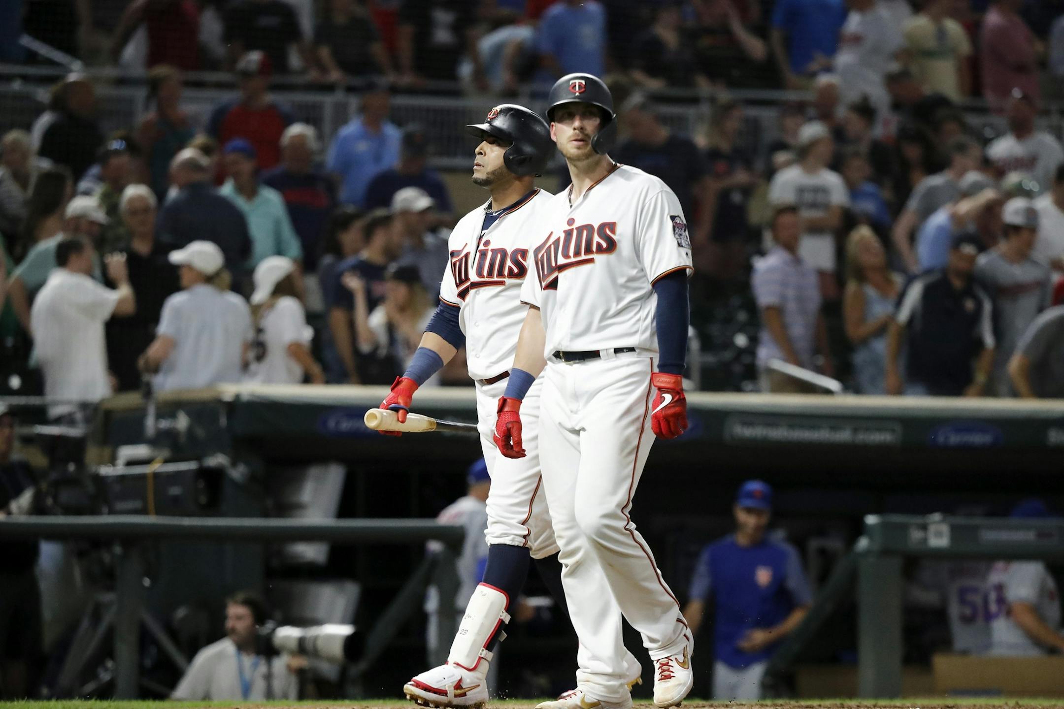 Minnesota Twins designated hitter Nelson Cruz (23), left, and Minnesota Twins catcher Mitch Garver (18) walk off the field after losing.