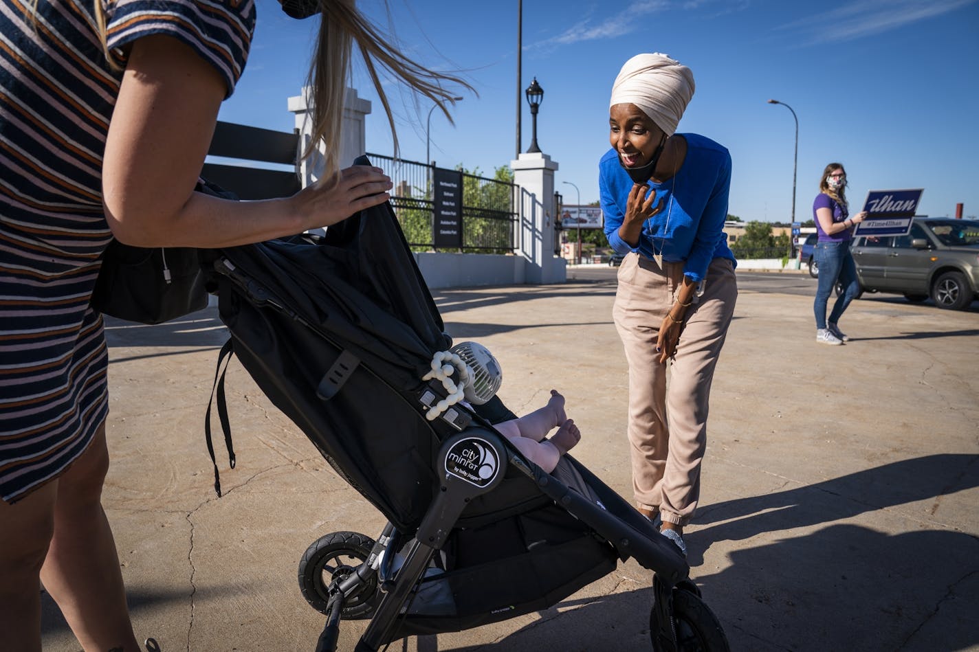 U.S. Rep. Ilhan Omar greeted Adrienne Aarts, left, and her nine-month-old baby Isabel at the corner of NE. Broadway and Central Avenue in Minneapolis.