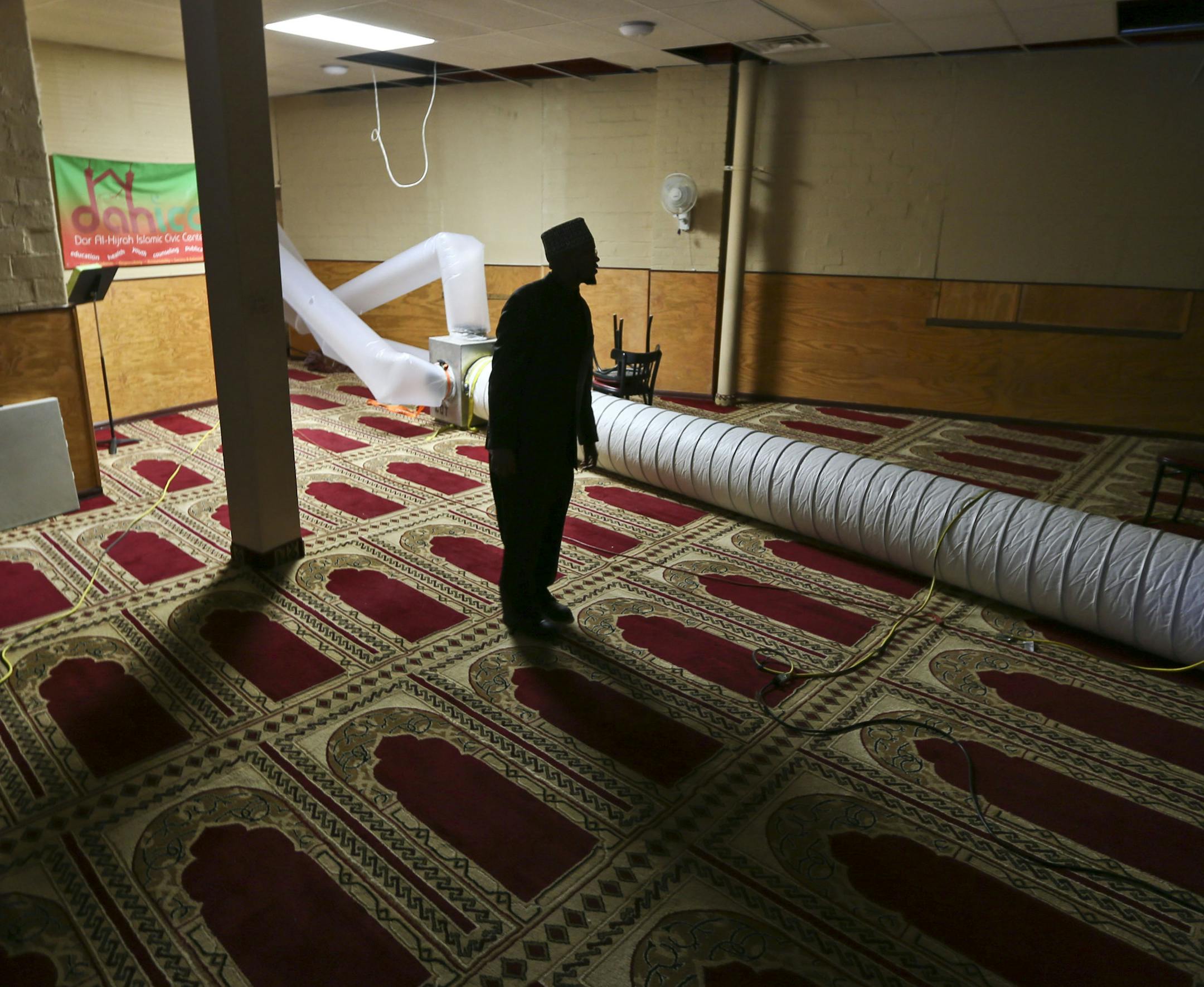 Imam Sharif Mohamed walked through the mosque Dar Al-Hijrah on Thursday, January 9, 2014, in Minneapolis, Minn. The mosque was damaged in the apartment fire next door that killed three men. It is currently being cleaned and aired out which is what the tubing it for. ] RENEE JONES SCHNEIDER ‚Ä¢ reneejones@startribune.com ORG XMIT: MIN1401091608110396