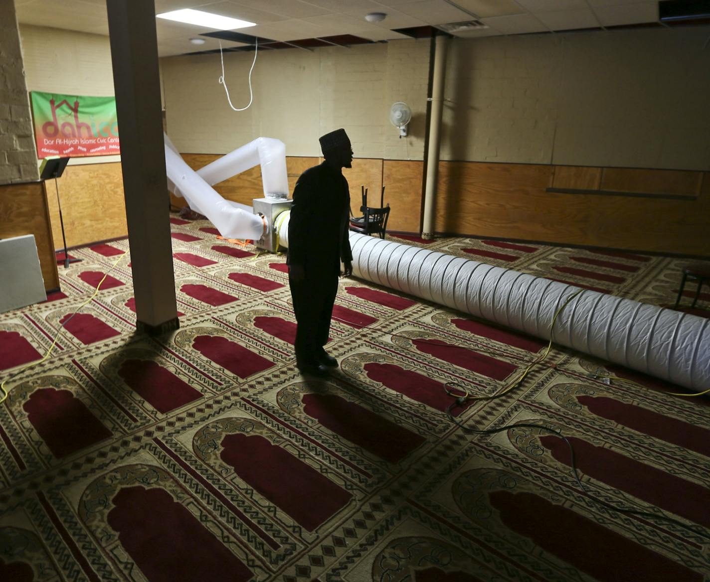 Imam Sharif Mohamed walked through the mosque Dar Al-Hijrah on Thursday, January 9, 2014, in Minneapolis, Minn. The mosque was damaged in the apartment fire next door that killed three men. It is currently being cleaned and aired out which is what the tubing it for. ] RENEE JONES SCHNEIDER &#x201a;&#xc4;&#xa2; reneejones@startribune.com ORG XMIT: MIN1401091608110396