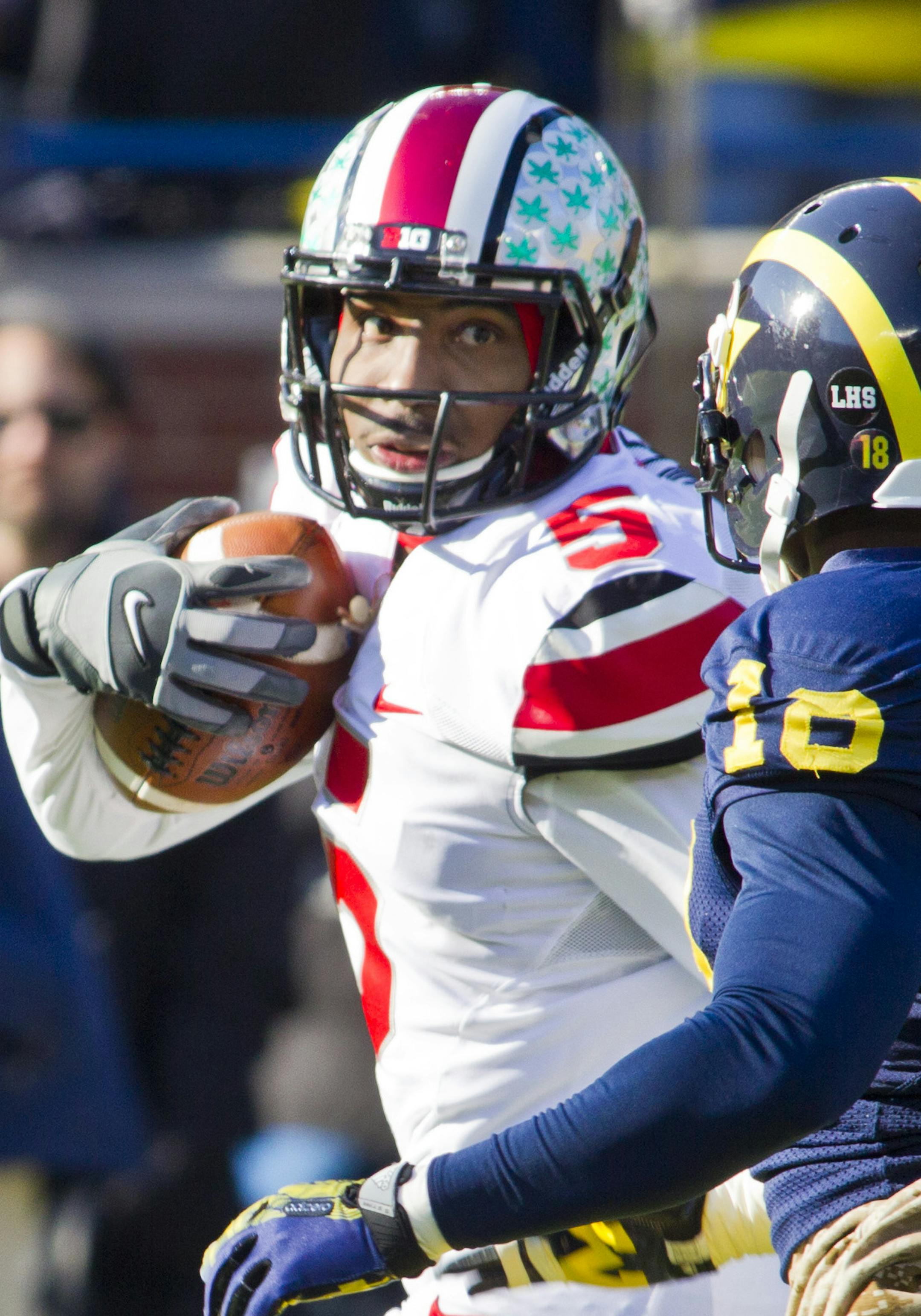 Ohio State quarterback Braxton Miller (5) looks back at Michigan defensive back Blake Countess (18) as he rushes for a touchdown in the first quarter of an NCAA college football game in Ann Arbor, Mich., Saturday, Nov. 30, 2013. (AP Photo/Tony Ding)