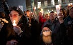 Mitch Grauberger, of Columbia Heights, and Lou Zurn, left, of Minneapolis, raise their candles after a speech by Minneapolis City Council President An