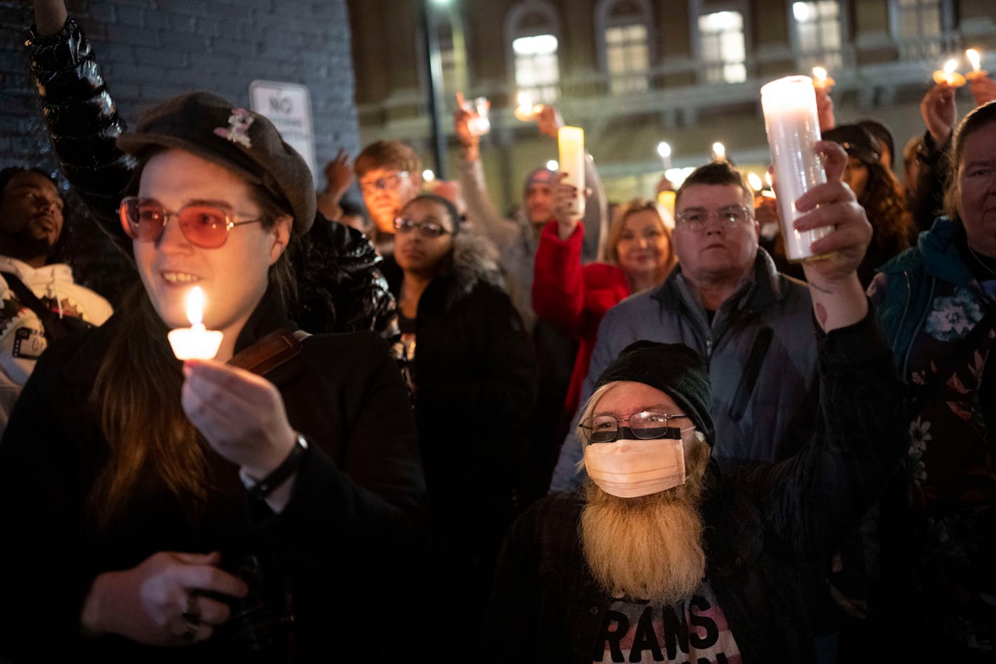 Mitch Grauberger, of Columbia Heights, and Lou Zurn, left, of Minneapolis, raise their candles after a speech by Minneapolis City Council President Andrea Jenkins Wednesday, Nov. 23, 2022 outside the Saloon in Minneapolis, Minn.. A vigil was held to remember the victims of a mass shooting this past Saturday night at Club Q, an LGBTQ bar in Colorado Springs, in which five people were shot and killed and more than a dozen injured. ] AARON LAVINSKY • aaron.lavinsky@startribune.com