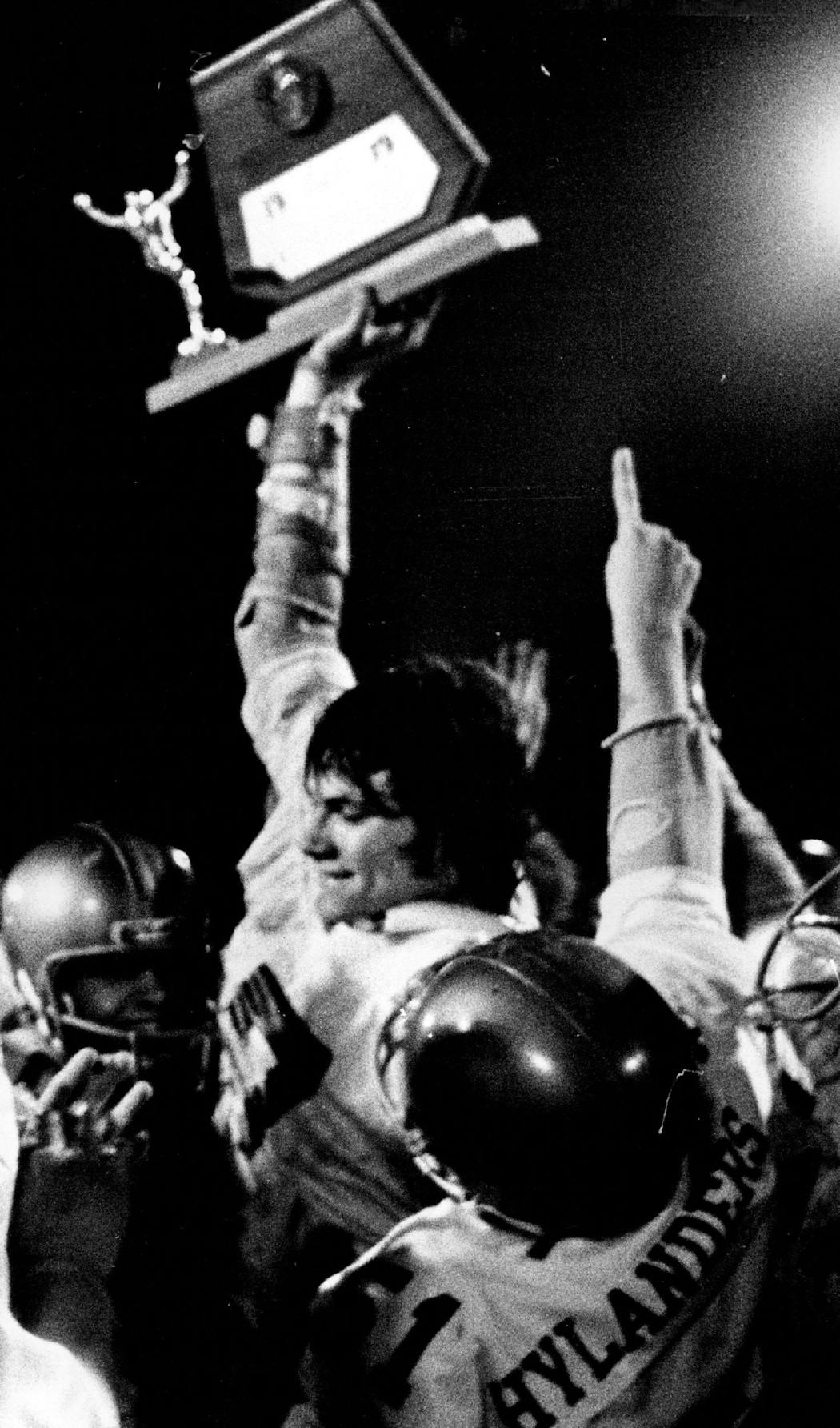 John Alt, at 6-7, holds up the Class AA championship football trophy after Columbia Heights defeated Richfield in 1979. 
