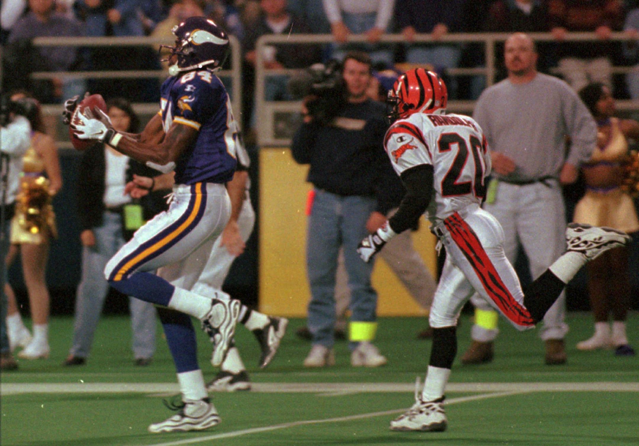Minnesota Vikings wide receiver Randy Moss, left, hauls in a 61-yard touchdown pass from quarterback Randall Cunningham as Cincinatti Bengals corner back Thomas Randolph, right, pursues him in the fourth quarter in Minneapolis, Sunday, Nov. 15, 1998. The Vikings beat The Bengals 24-3. (AP Photo/Paul Battaglia) ORG XMIT: MIN2017012218320832