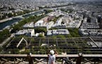 A visitor looks at the view from the Eiffel Tower, in Paris, Thursday, June 25, 2020. The Eiffel Tower reopens after the coronavirus pandemic led to t