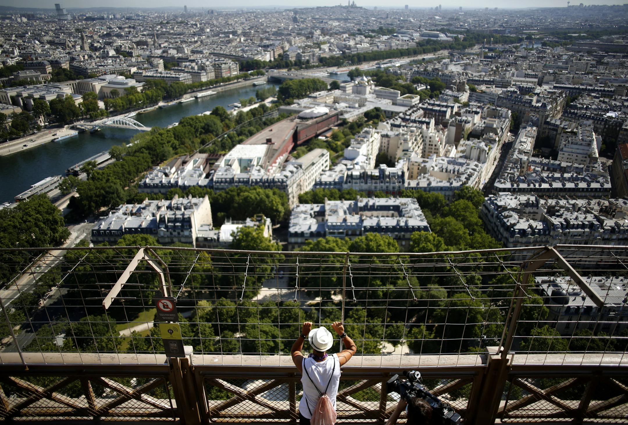 A visitor looks at the view from the Eiffel Tower, in Paris, Thursday, June 25, 2020. The Eiffel Tower reopens after the coronavirus pandemic led to the iconic Paris landmark's longest closure since World War II. (AP Photo/Thibault Camus)