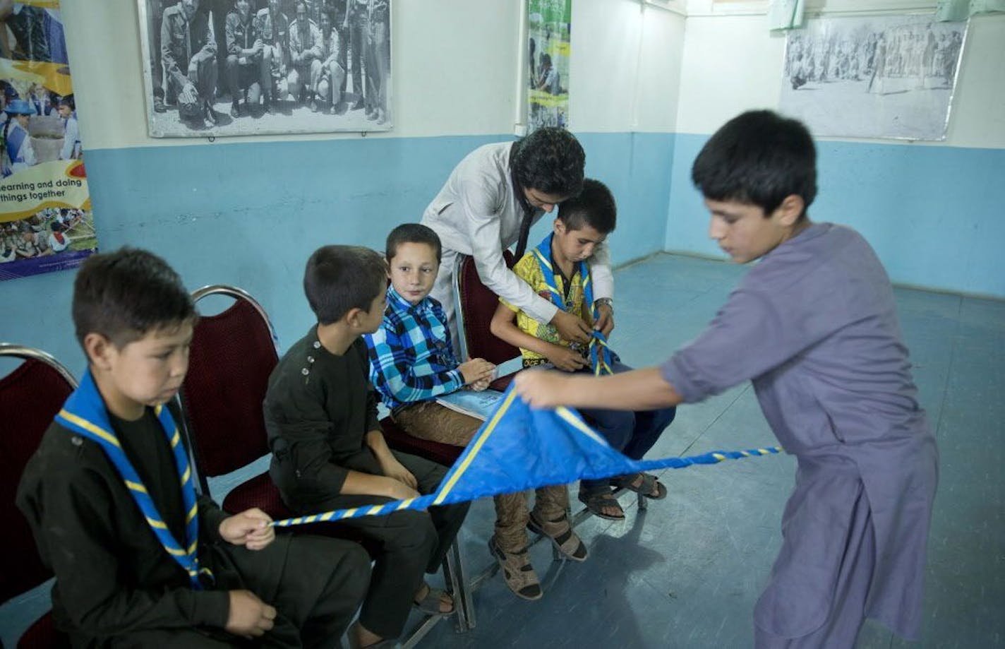 In this Tuesday, Aug. 9, 2016 photo, Afghan scouts tie their scarves before practicing songs by Prince at Physiotherapy and Rehabilitation Services for Afghanistan (Parsa) center in Kabul, Afghanistan. Parsa head Marni Gustavson's eyes brimmed with tears as she watched a dozen Afghan children learning the words to Prince's "Purple Rain." Parsa's building was in disrepair until a friend of it's cheif met Prince backstage at a Los Angeles concert in 2007 and told him how he could help Afghan child