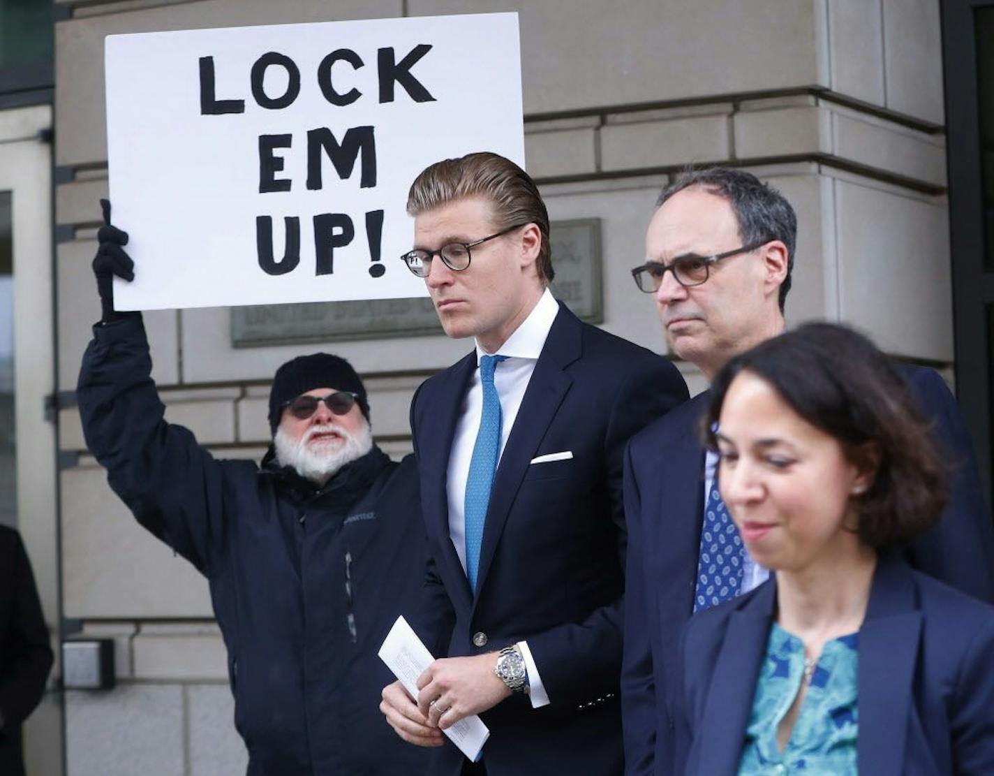 Alex van der Zwaan leaves Federal District Court in Washington, Tuesday, April 3, 2018. Holding the sign up is Bill Christeson from the Washington area. A federal judge sentenced Alex van der Zwaan to 30 days in prison.