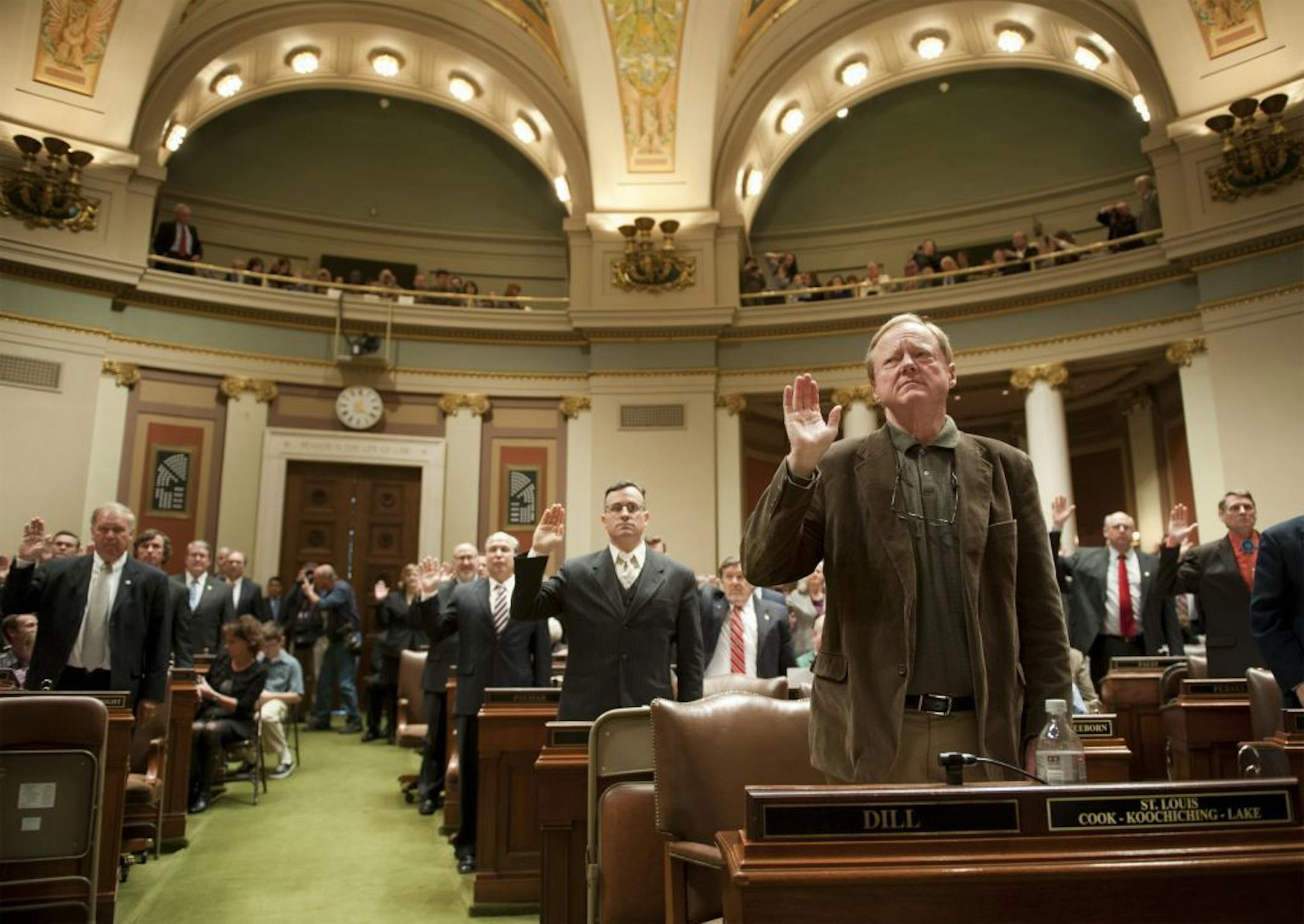 The swearing in ceremony in the House chambers on the right is Rep. David Dill.