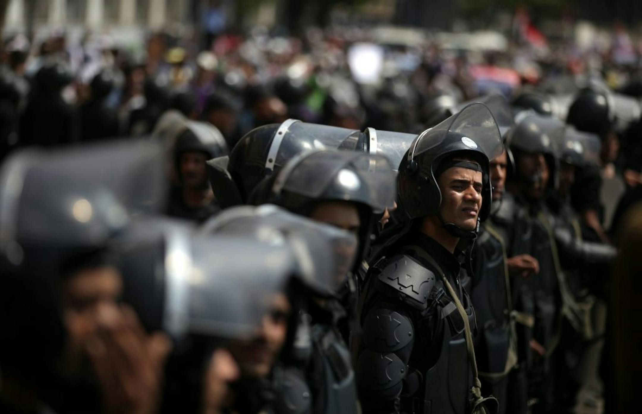 Egyptian riot police stand guard during a demonstration by supporters of ousted President Mohammed Morsi, near Tahrir Square in downtown Cairo, Egypt, Wednesday, July 17, 2013. Several hundred supporters of Egypt's deposed president massed outside the Cabinet building Wednesday in Cairo, expanding their protests denouncing the country's new government and demanding the reinstatement of Islamist leader Mohammed Morsi.