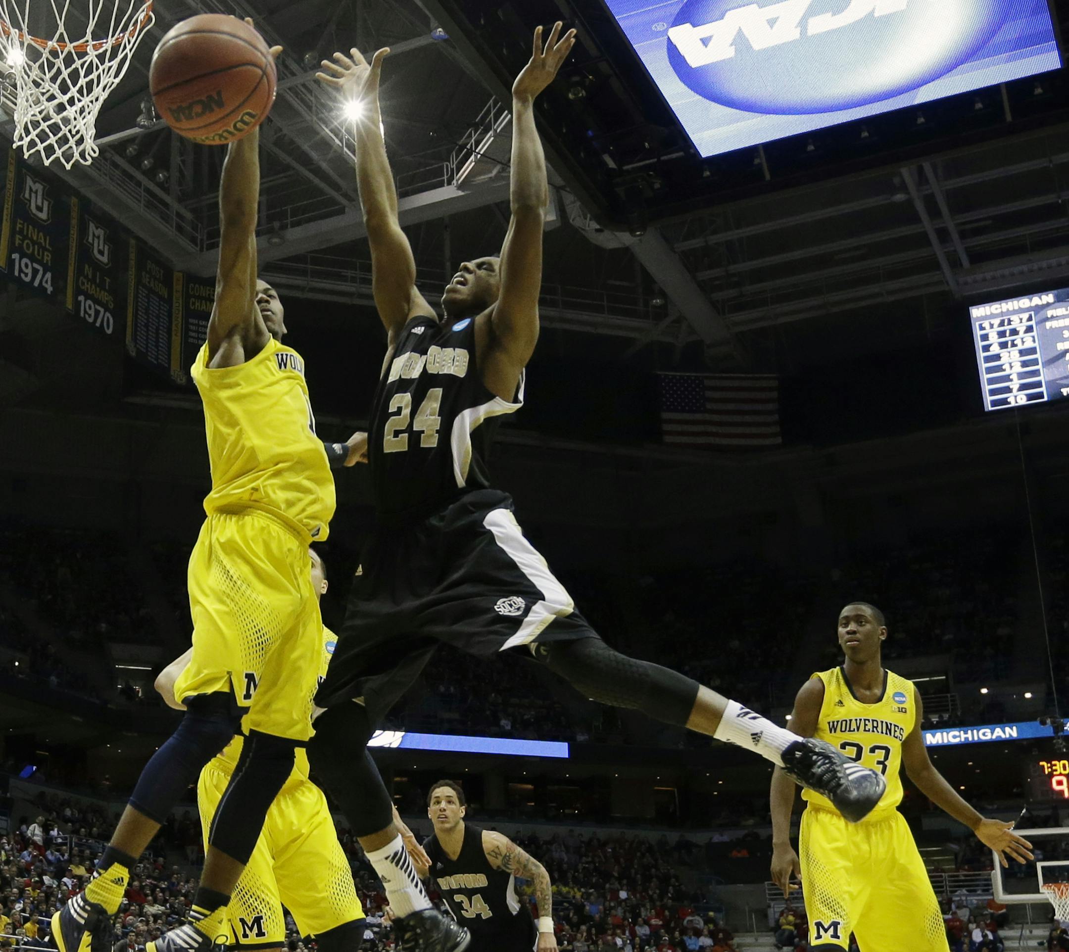 Michigan forward Glenn Robinson III, left, blocks a shot by Wofford forward Justin Gordon during the second half of a second round NCAA college basketball tournament game Thursday, March 20, 2014, in Milwaukee. (AP Photo/Morry Gash)