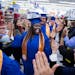 Walmart Academy graduate Jessica Hall, center, processes down the aisle of Walmart with fellow graduates to attend their ceremony. ] (Leila Navidi/Sta