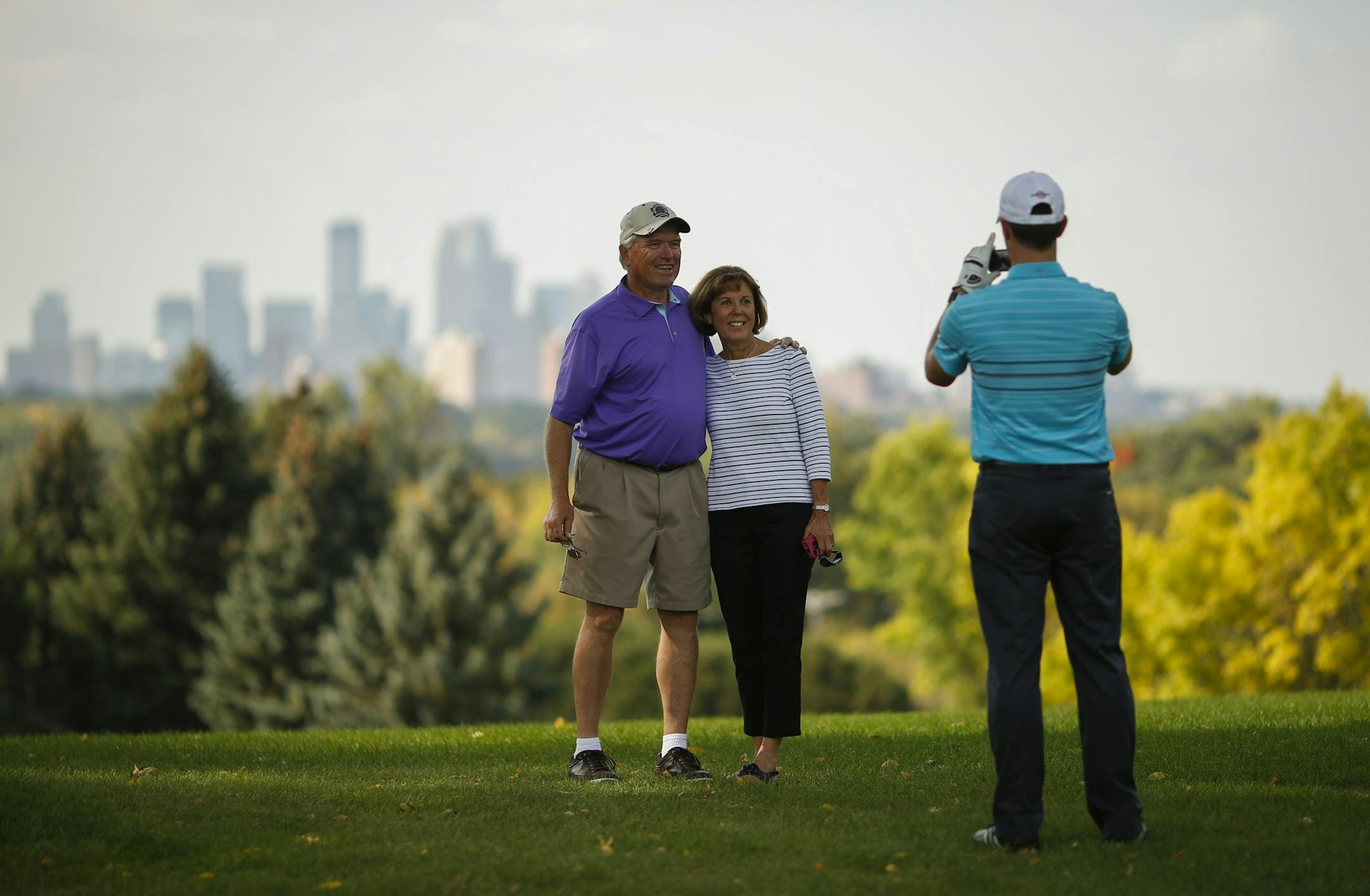 Art Hennington posed for a photo with his wife, Joni, taken by club pro Ryan Rindels during his round Thursday afternoon at Town and Country Club in St. Paul. ] JEFF WHEELER ‚Ä¢ jeff.wheeler@startribune.com Art Hennington accomplished his goal of golfing every course in Minnesota on Thursday, September 25, 2014 when he played the course at Town and Country Club in St. Paul. That's 491 courses played by the Elk River man. He just had a heart stint installed this week but he remai