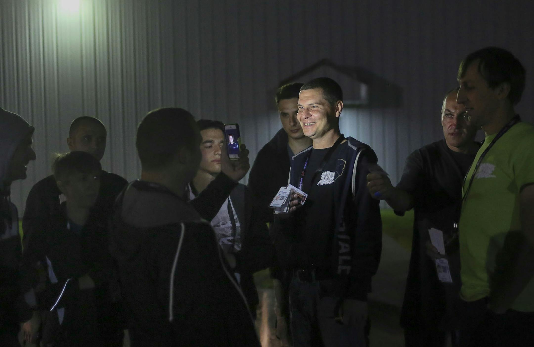 A group of mostly Ukrainian workers have come to Perham this summer for employment at KLN Enterprises, the family-owned parent company of Barrel O' Fun that also manufactures snack brands for other companies. Here, workers are photographed by each other with their work credentials after arriving at their work place at KLN Enterprises Wednesday, July 16, 2014, in Perham, MN.] (DAVID JOLES/STARTRIBUNE) djoles@startribune More than 60 international workers, mostly from Ukraine, are flew to Minnesot